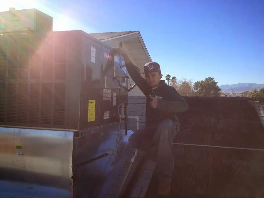 HVAC technician performing AC Tune-Up on a rooftop unit in Verona